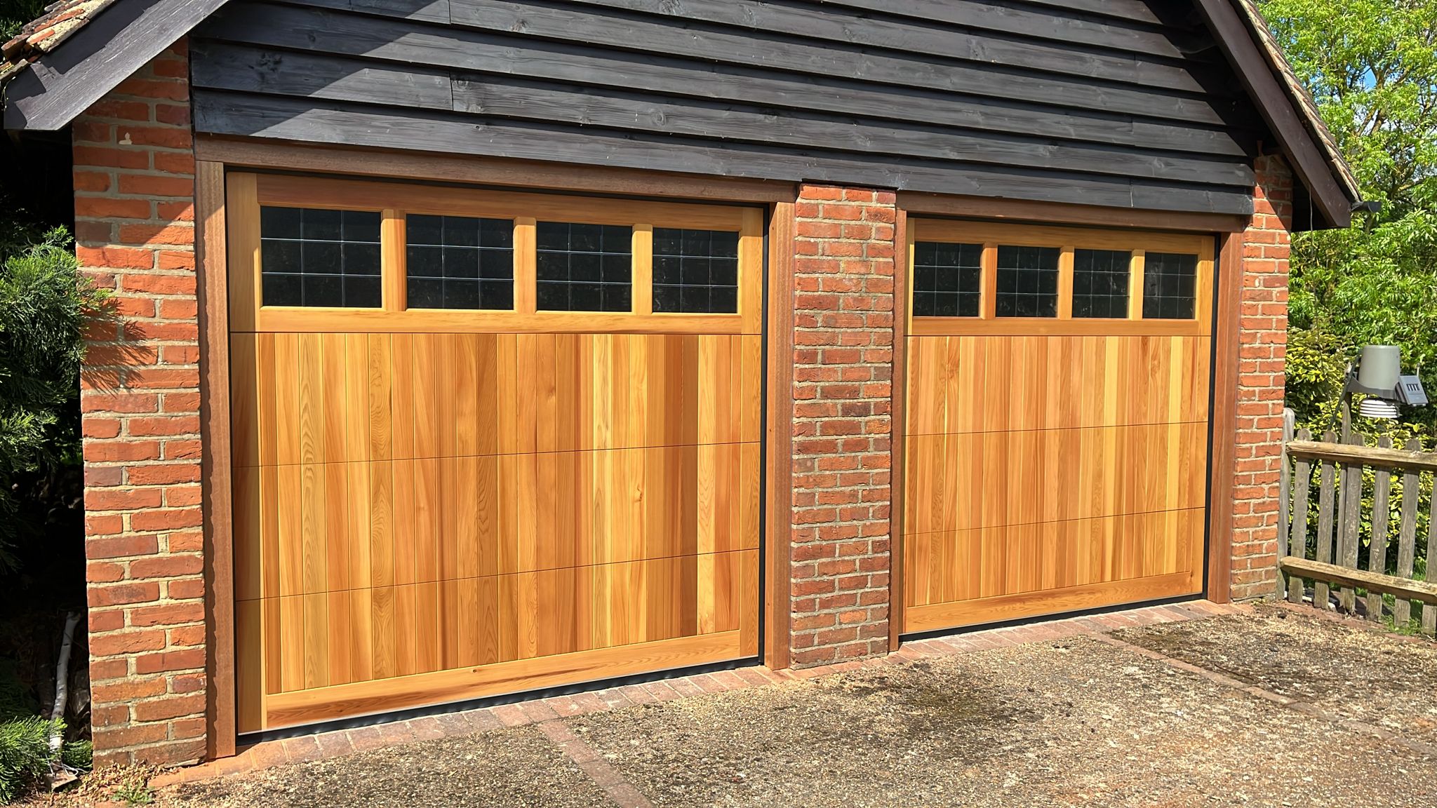 Sectional wooden garage door in a warm wood-tone finish, offering both beauty and durability.